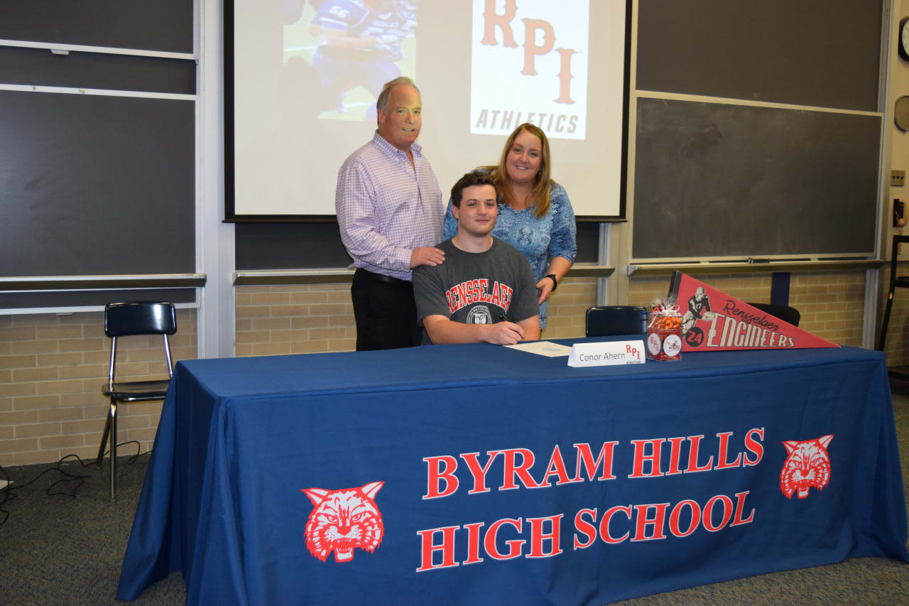 Conor Ahearn, with his parents, signed his letter of intent to play football at RPI