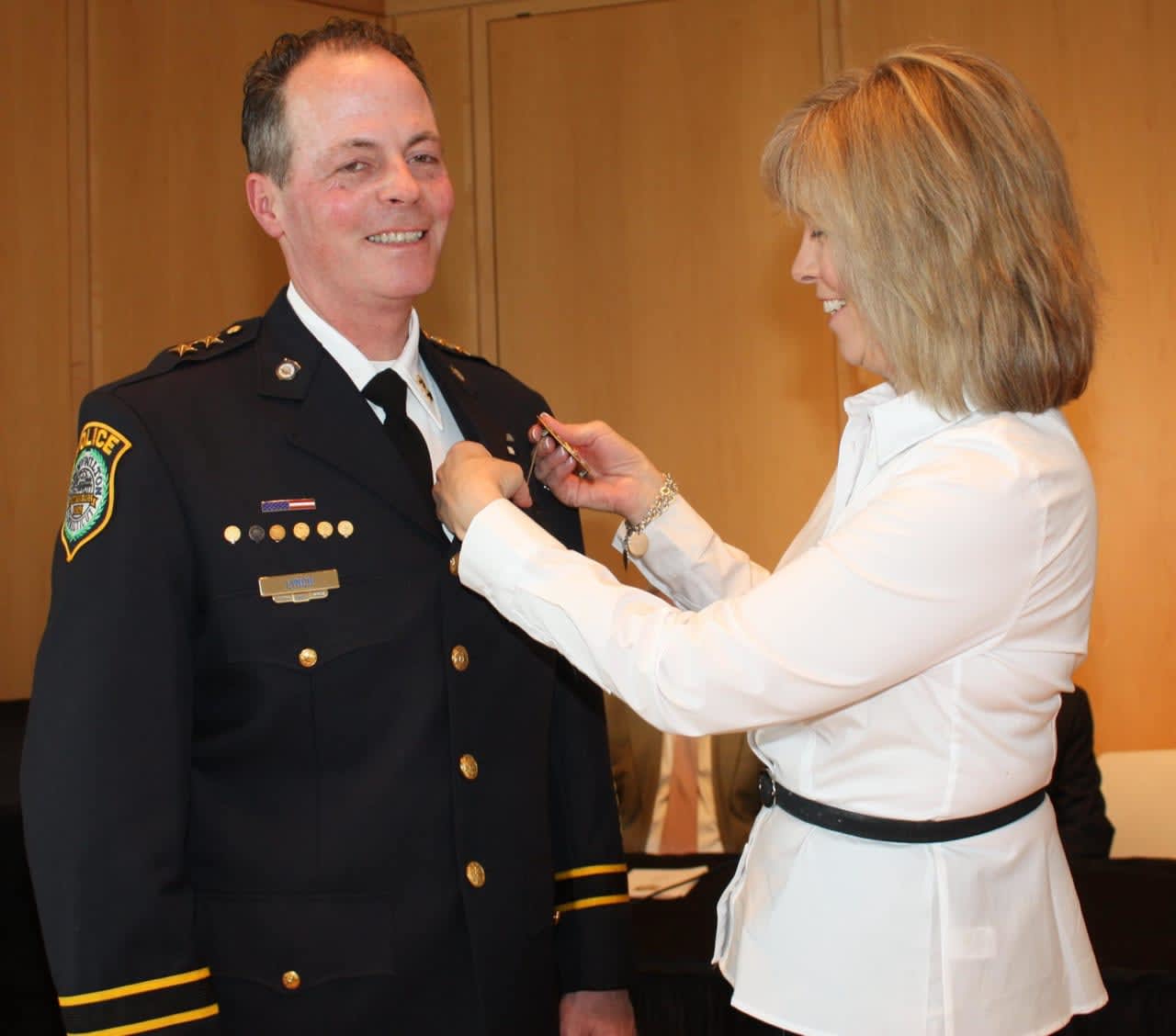 New Wilton Police Chief John Lynch is presented with his new badge by his wife, Ann.
