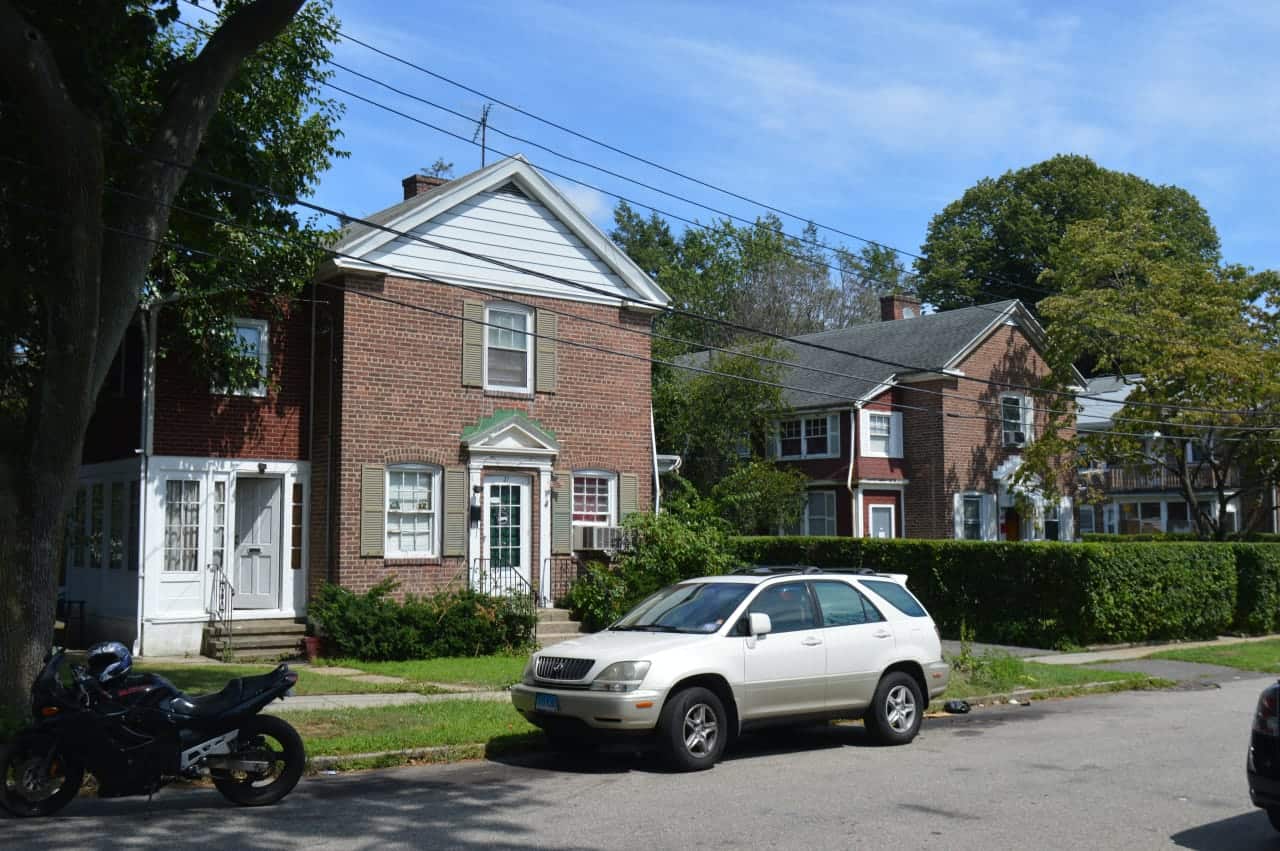 At least two shooters are believed to have shot 13 people partying in the back of 19-21 Plymouth Street, left, from the hedges in the backyard at