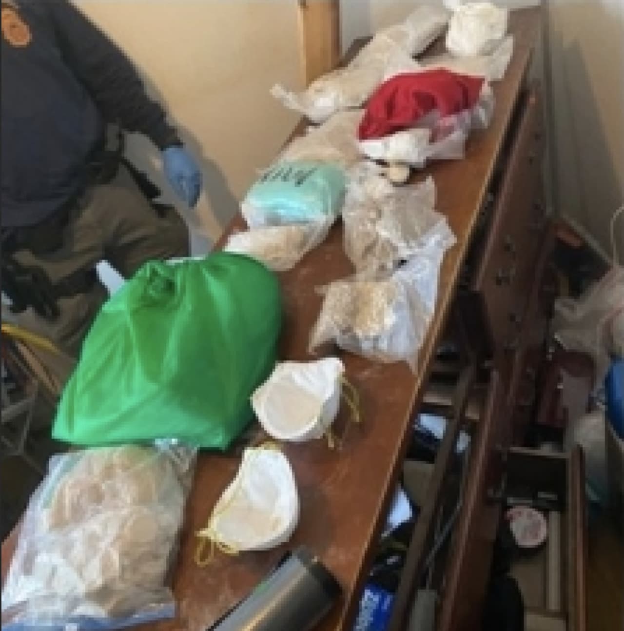 Agents show off some of the items they seized from Benito Bello's Bronx home. That included 14 kilograms of fentanyl, one kilogram of cocaine, a kilogram press, a pill press, and a scale, the DEA said.