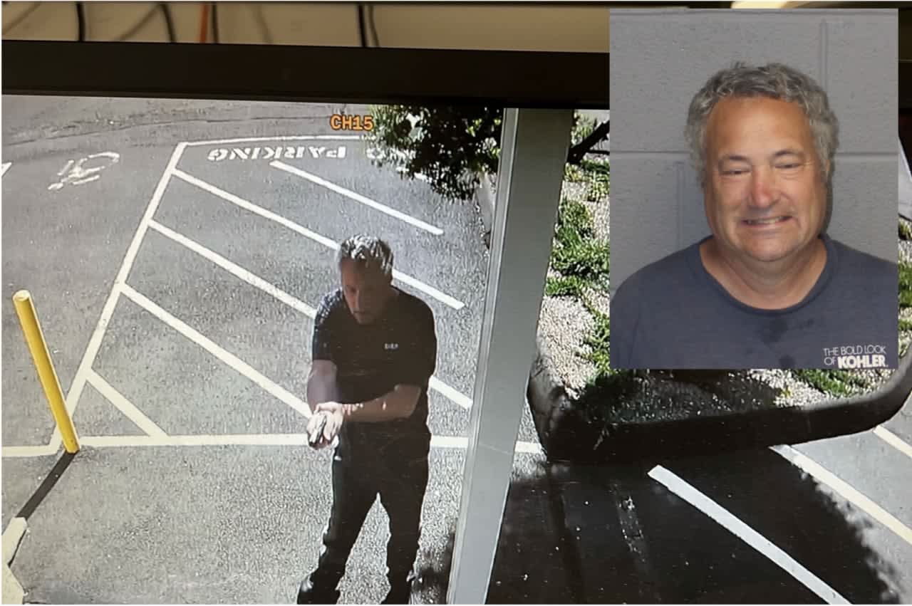 Philip Caseria pictured outside the wine shop with a drawn, loaded gun.
