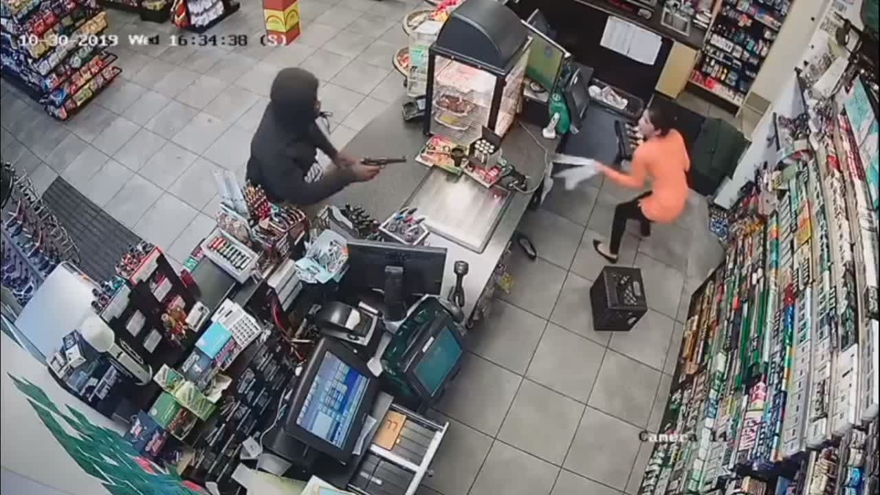 A man is seen pointing a gun at a clerk during the robbery of a Bloomfield gas station last week