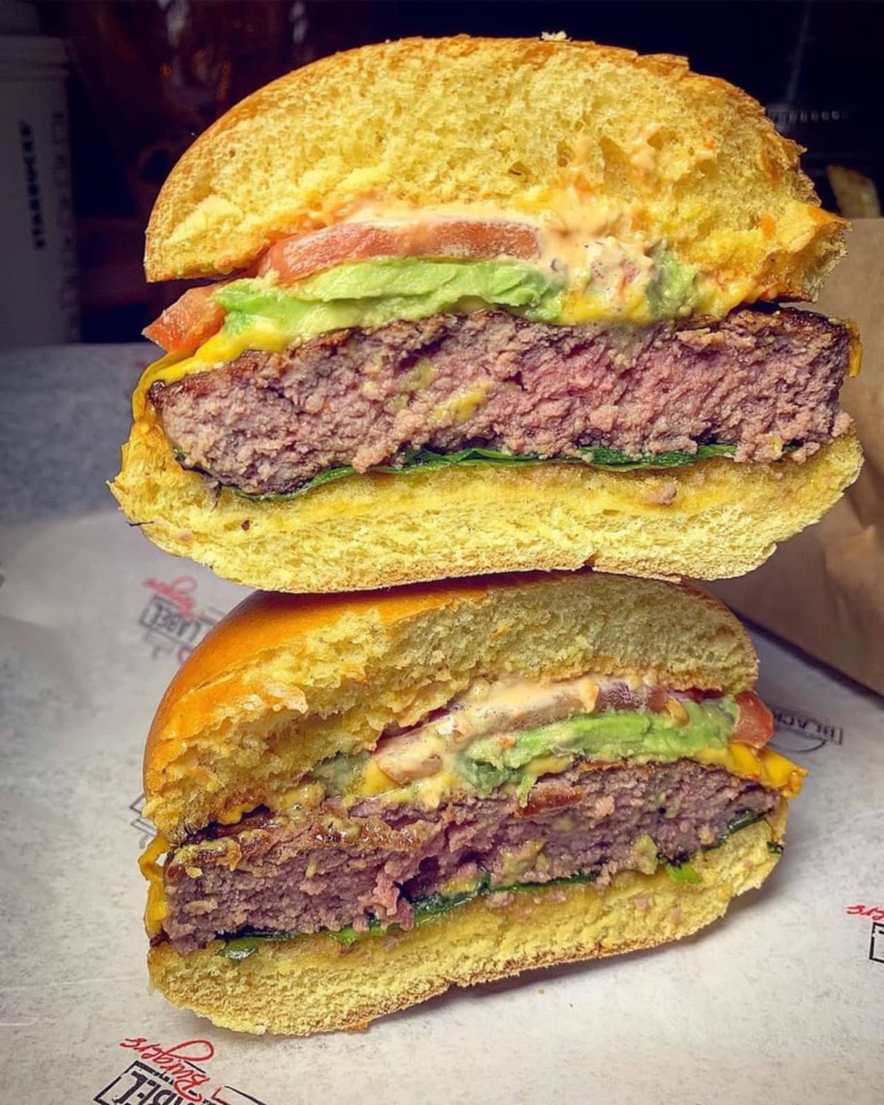 Black Label burger with American cheese, lettuce, tomato, onion and label sauce (avocado added) from Black Label Burgers, located at 683 Old Country Road in Westbury