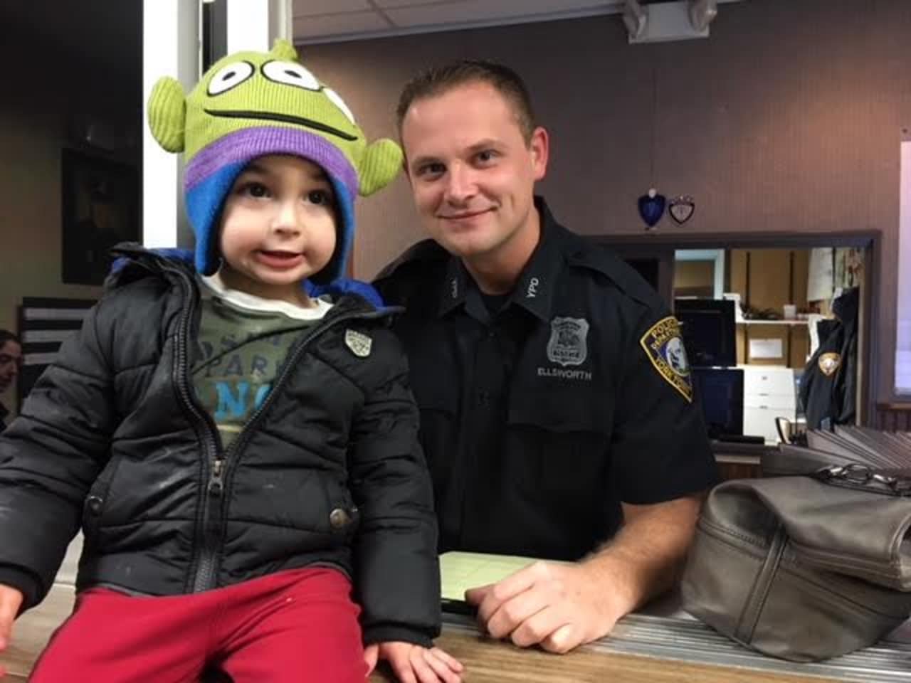 Three-year-old Landon Pruyne poses with a Yorktown Police Officer after turning in a wallet he found.