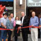 Fair Lawn Chocolate Works owner Andrea Collins, fourth from left, Mayor John Cosgrove, third from left, and Fair Lawn officials cut the ribbon on the new candy store.
