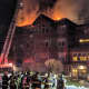 Flames shoot through the roof of the burning condo on Richards Avenue in Norwalk on Monday evening.