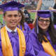 Two students in cap and gown ready to graduate.