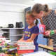 Second grader Sophie Kwun gets some help organizing the donations from her mom, Susan