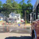 Runners cool off by trotting through a spray set up by Bethel's fire and emergency services departments Monday.