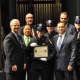 White Plains Police Officer Amy Carelli, center, received her Police Academy training certificate from Commissioner David E. Chong (left of her) and was joined on stage by several family members who also are serving or retired as police officers.