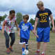 Jeremy dribbles up the field with support from his mom and a Saddle Brook High School soccer player.