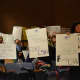 Supporters of Legal Services of the Hudson Valley hold up signs at a Westchester County budget hearing.