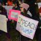 A demonstrator holds a sign calling for President Donald Trump's impeachment. The demonstrator was at a vigil in Chappaqua, which were held as a protest against Trump's order banning admission of refugees.