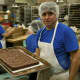 A baker with a freshly-iced tray of brownies.