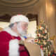 Santa Claus writes children’s wishes down at the Lockwood-Mathews Mansion’s Holiday Open House
