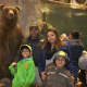 A family poses with a stuffed bear at Bass Pro.
