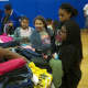 A volunteer helps kids with clothes at Saturday's event.
