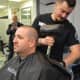 Det. Sgt. Adam Hampton halfway through his shave experience with barber Michael Aspinwall.