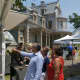 Visitors view artwork at the Norwalk Art Festival on Sunday in the shadow of the Lockwood-Mathews Mansion.