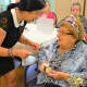 Nina Gomez, recreation leader at the Gallen Adult Day Center, serves Bessye Shulman birthday cake.