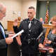 Hillsdale Mayor Douglas Frank swears in Patrolman Corey Rooney as his mother, Patti Rooney, looks on, and his father, Rick Rooney, holds the Bible.