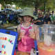 A young girl offers a great deal on cold lemonade on a steamy afternoon.
