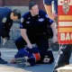Police prepare to load the suspect into an ambulance.
