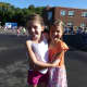 Holmes School second-grader Lila McKeone and third-grader Sylvia Mickels are excited to see each other during morning recess on the Holmes School playground.