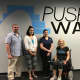 Push to Walk staff Executive Director David Font, Operations Director Stephanie Lajampose, and Program Director Tiffany Warren stand with client Lois Hamilton.