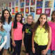 Art teacher Genecie Azzollini stands with her Maywood Avenue students at the spring art exhibit.