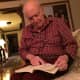 John Grande of Teaneck, 84, reads a chapter from his book, "Scorekeeper at the Met."