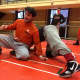 First-year Dumont wrestling coach Mike Rooney works through new skills with senior Mike Vietri.