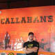 Dan DeMiglio, owner of Callahan's, appears next to a mural in his Norwood eatery.