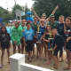 Members of the Maywood Dolphins Swim Team and coaches pose with the league championship trophy.