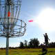 Disc golf is played by throwing golf discs into baskets attached to poles.