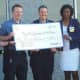 Ramapo police officers hold a check for $1,000 from Walmart intended for the DARE program.
