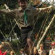 A happy Scout traverses the rope bridge.