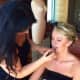 Victoria De Los Rios applies makeup to a client's face.