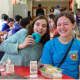 Two girls eating blue donuts to show their support for World Autism Day