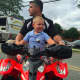 Tyler, 3, gets a ride from Paramus Police Officer Brian Linden with the department's motorcycle unit.