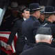 Pallbearers bring out the casket of Putnam County Undersheriff Peter Convery following his funeral inside a Mahopac church.