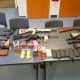 Seven handguns, six rifles, numerous high capacity magazines, ammunition, marijuana, and various firearm equipment were seized by police.