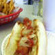 Grilled onions and ketchup top a fried dog at Swanky Franks in Norwalk.