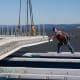 Works continues on the new Tappan Zee Bridge. A worker is shown guiding the placement of a prefabricated road deck panel last week.