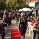 An Ossining resident makes her way down the red-carpet runway during the Fall Food and Fashion Show at Market Square on Saturday.