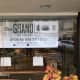 A sign in the window proclaims the upcoming opening of the Granola Bar in Greenwich. 
