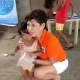 Julie Cox hugs a little Filipino girl during one of her many food and medical missions to the Philippines.