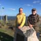 Phil Blagys, former president of the Black Rock Community Council, and Stuart Sachs, who leads the Council's Lighthouse Committee, stand at St. Mary's By the Sea, a Bridgeport park overlooking the Black Rock Lighthouse, visible in the distance.