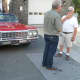 Hastings' Karl "Corky" Soderstrom, right, talks with a film crew member about his classic car used in Monday's filming.