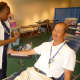 New York Blood Center phlebotomist Karlean Darby takes  blood from Poo Phopitue at the Hastings Library.